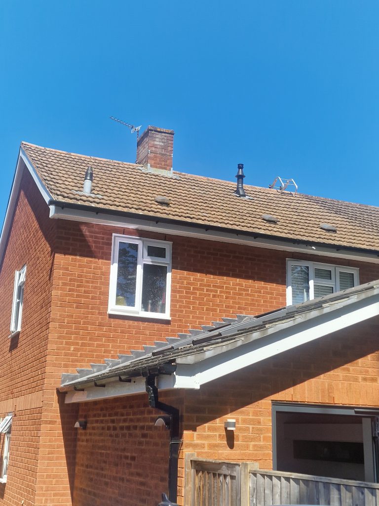 Brick house with a clean tile roof and white gutters