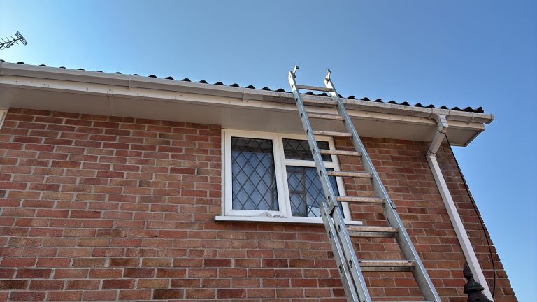 Ladder at the gutter line of a brick house in Hampshire